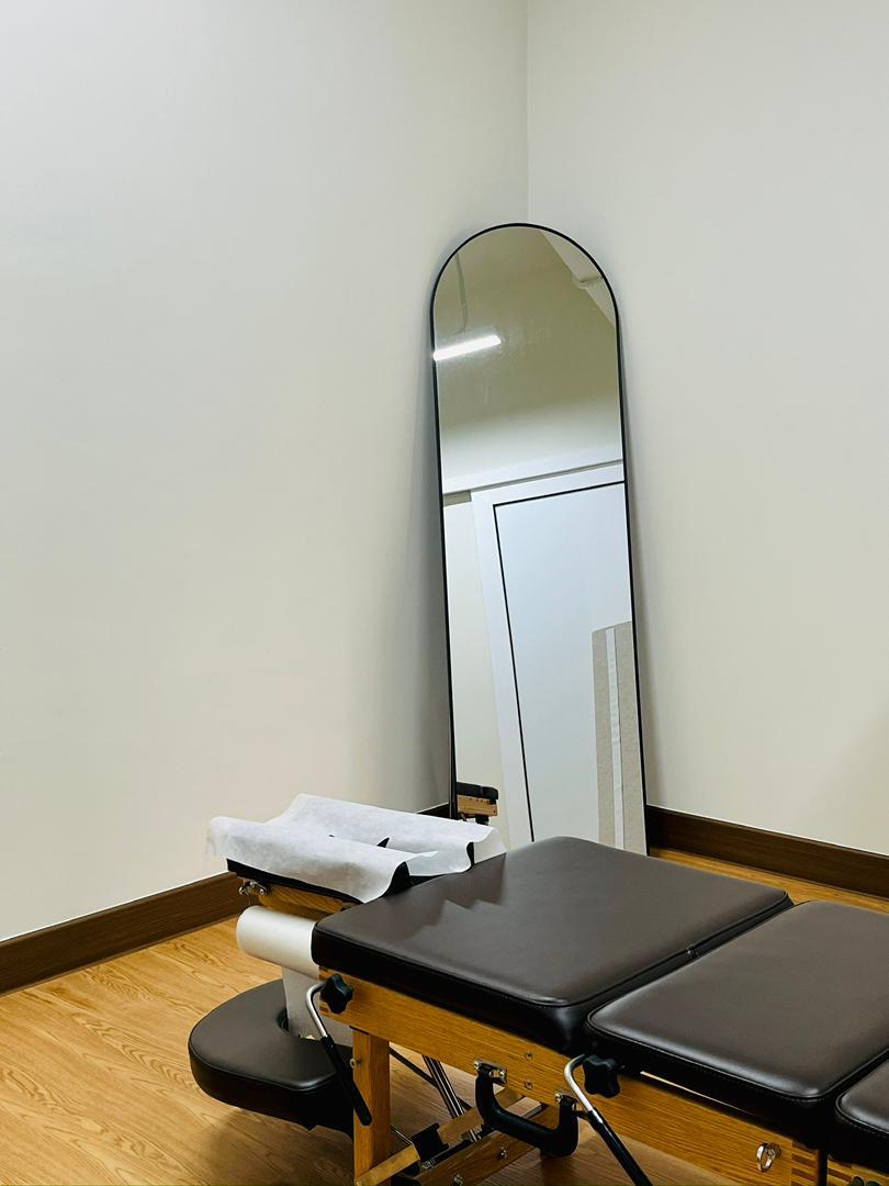 Chiropractic adjustment room with a treatment table and mirror